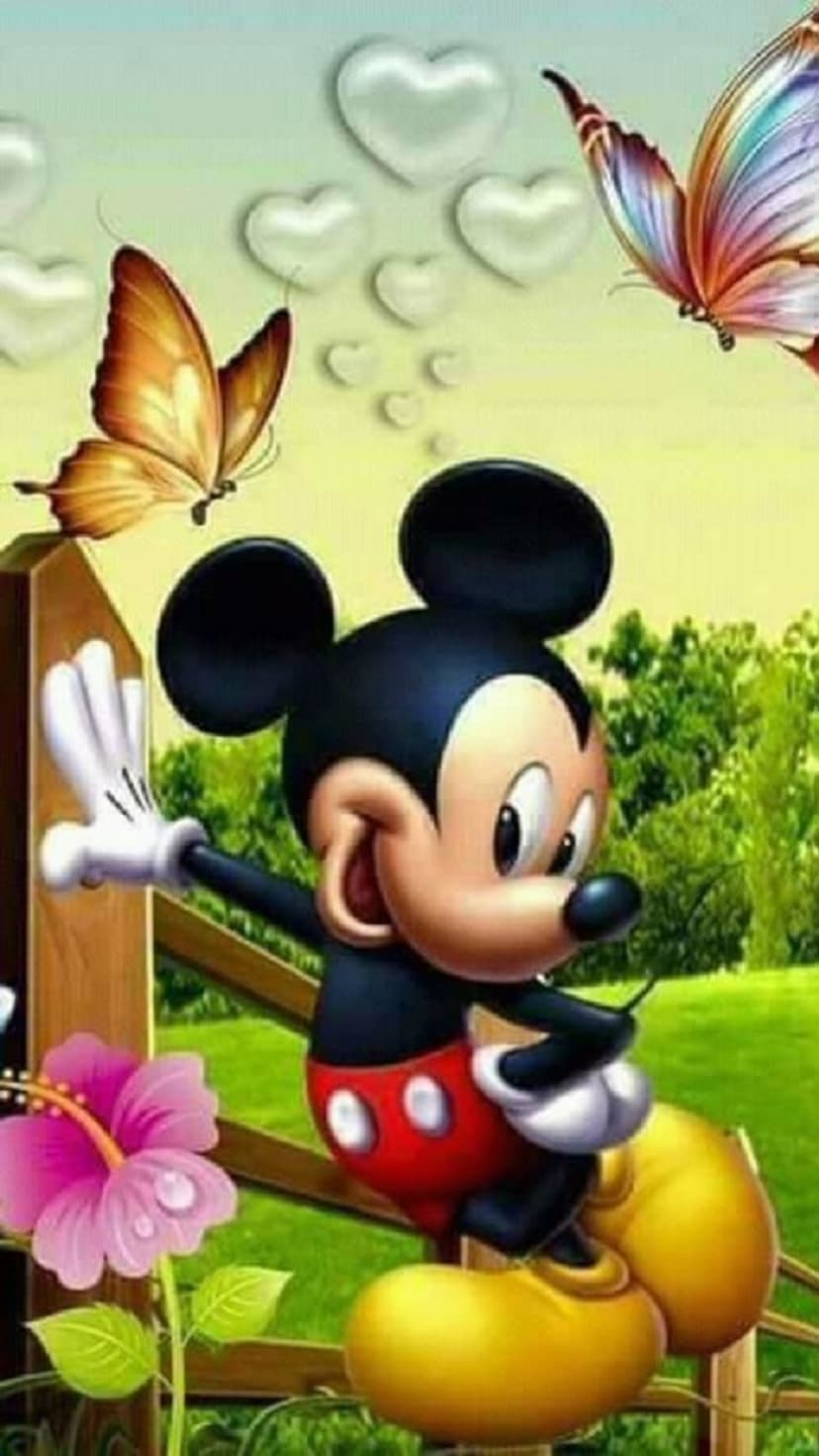 Mickey Mouse sits on a fence with pink hibiscus flowers and butterflies under a heart-filled pastel sky.