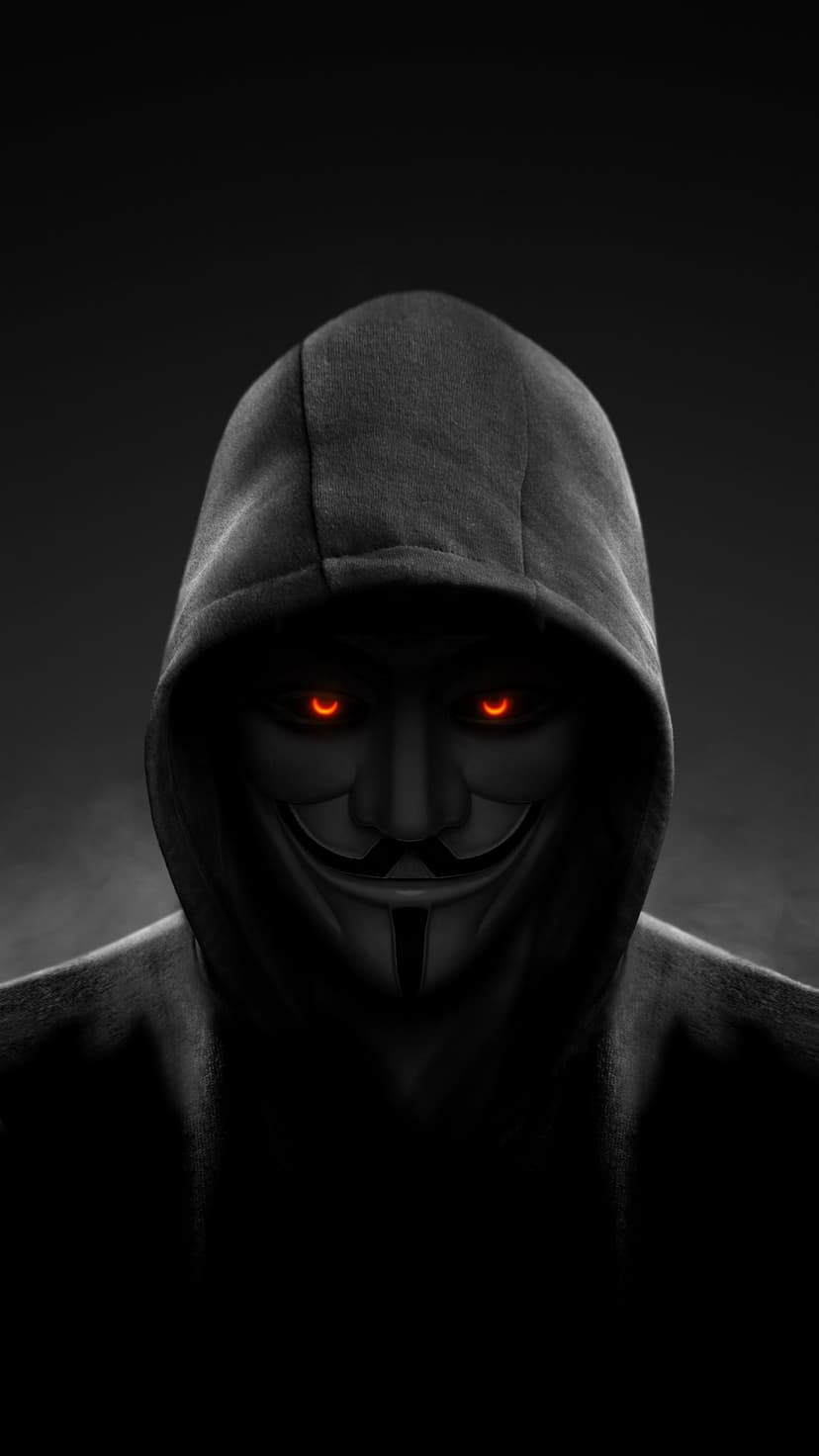 Anonymous mask featuring glowing red eyes and a dark hoodie stands against a hazy, smoke-filled backdrop.