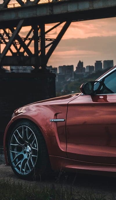 Metallic Red BMW Wheel and Urban Bridge Phone Background