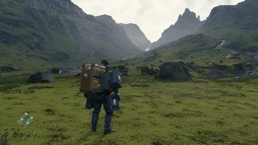 Sam Porter Bridges with a heavy cargo pack stands in a vast green rocky valley under misty mountains.