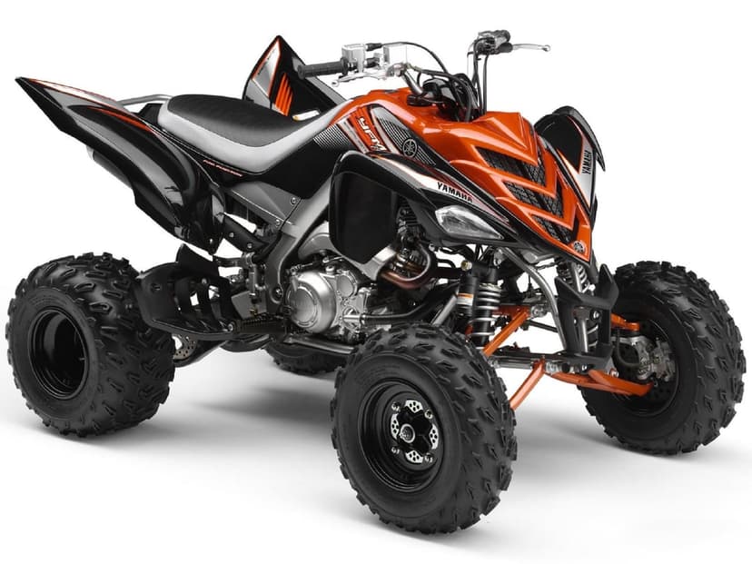 Yamaha Raptor 700R Special Edition ATV in orange and black with knobby tires on a white background.