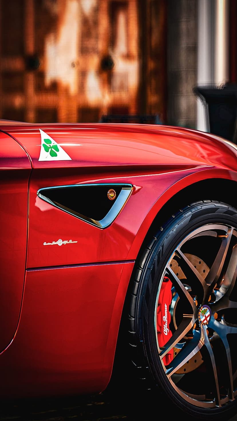 Red Alfa Romeo Giulia Quadrifoglio fender featuring a clover badge, dark alloy wheels, and red brake calipers.
