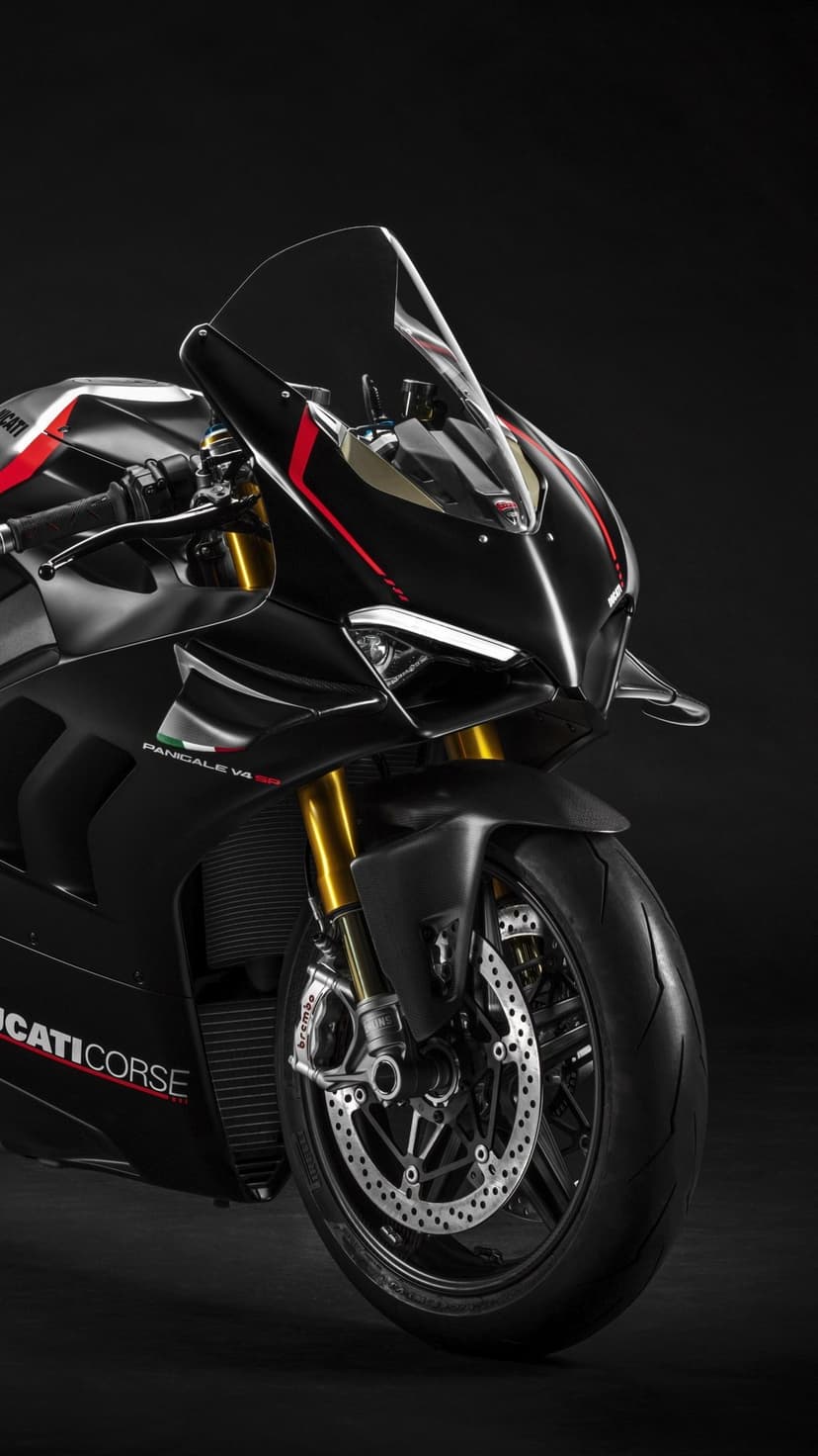Matte black Ducati Panigale V4 SP motorcycle with red accents and gold forks against a dark studio background.