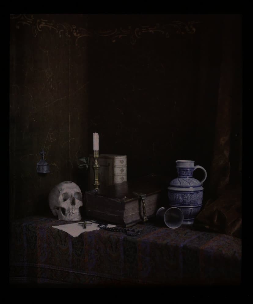 Human skull resting on old leather books beside a lit candle and patterned blue vase in dark shadows.