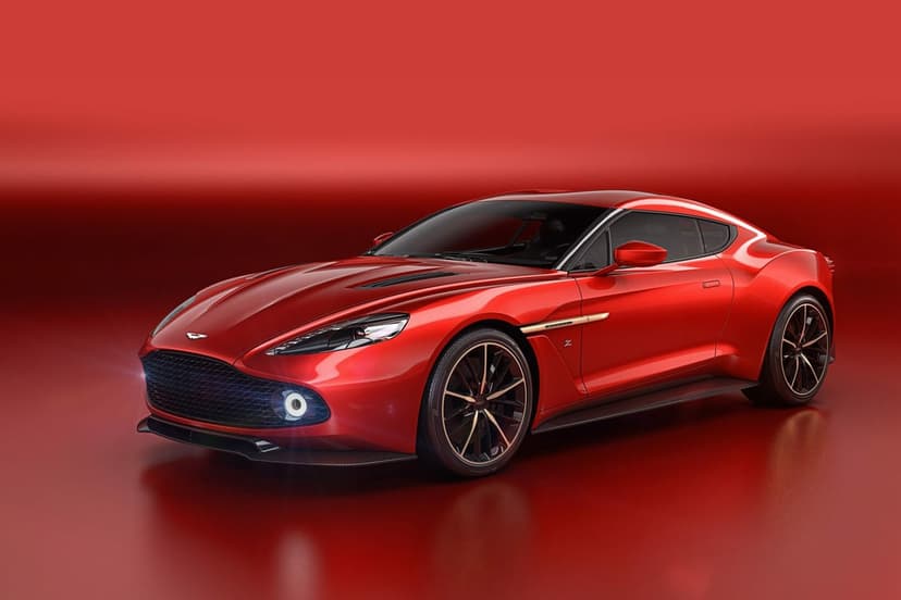 Red Aston Martin Vanquish Zagato sports car with circular LEDs and carbon fiber trim in a red studio.