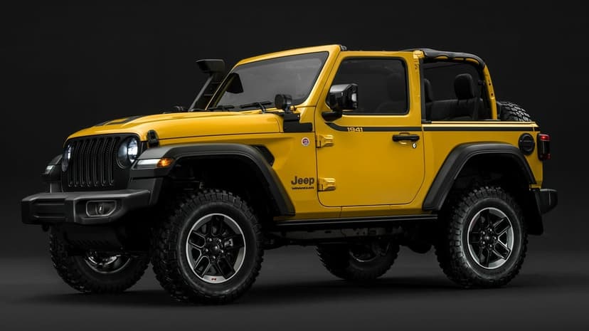 Modified yellow Jeep Wrangler featuring off-road tires and a snorkel intake against a dark studio background.