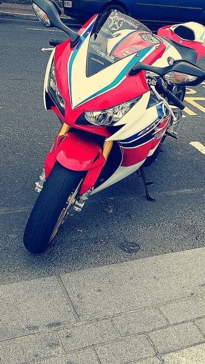 Red White Blue Honda CBR Motorcycle Parked on Street
