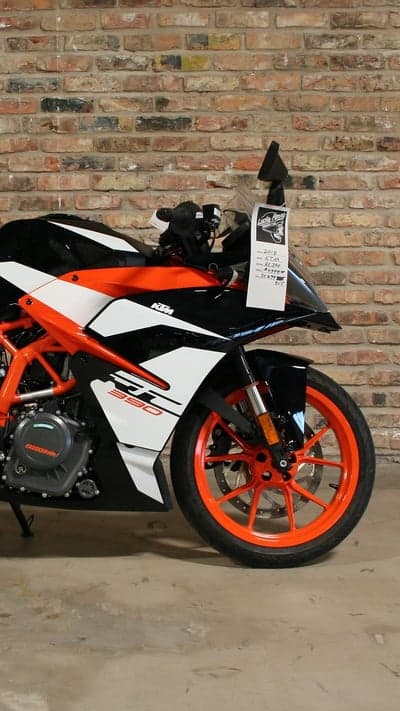 KTM RC 390 motorcycle with orange wheels and brick wall