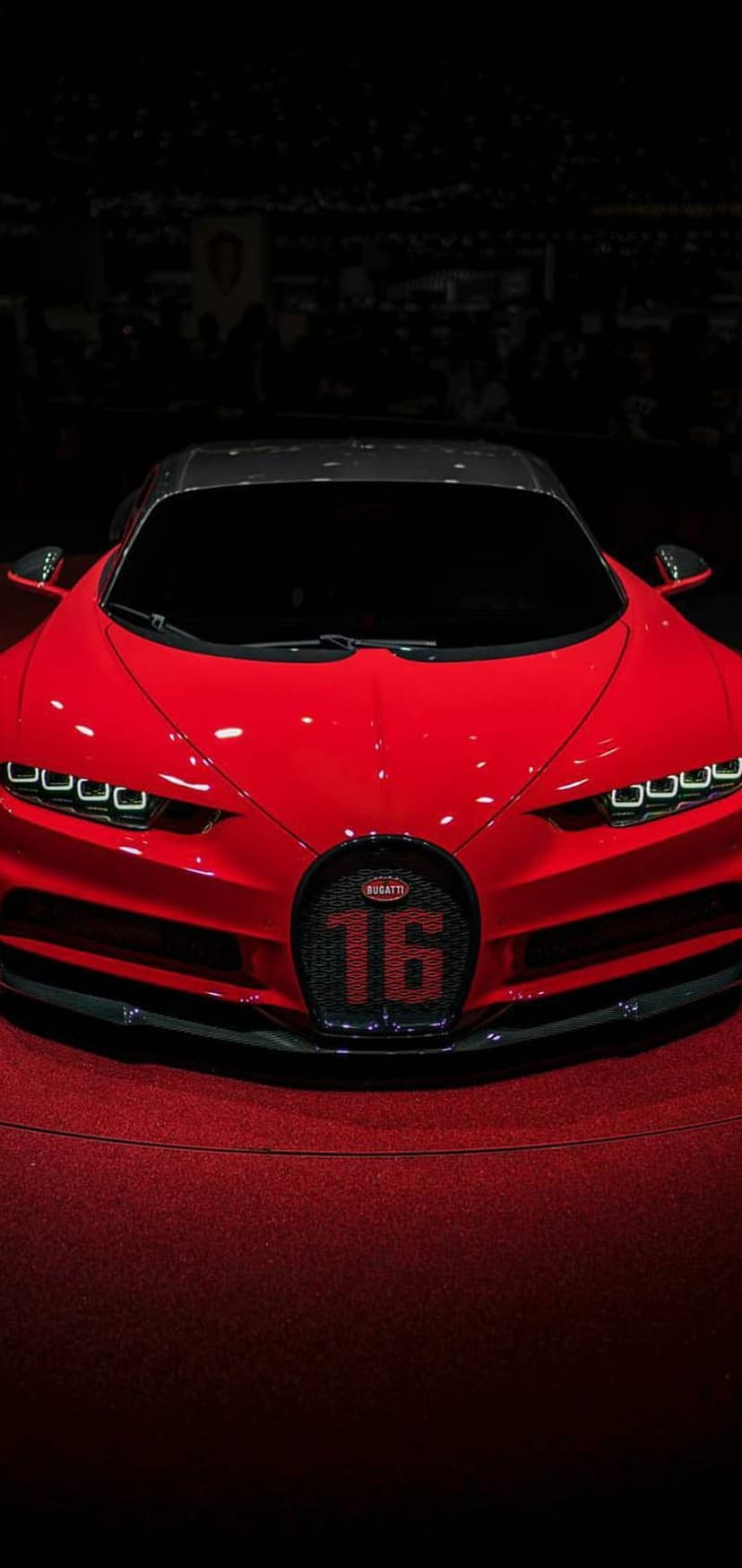 Bugatti Chiron Super Sport 300+ in red featuring a carbon fiber roof and sharp LED headlights on a plush carpet.