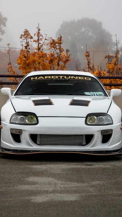 White Toyota Supra with Hardtuned decal in fall
