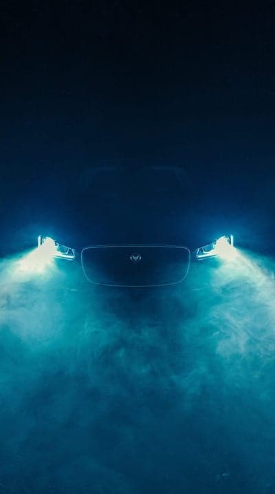 Moody Jaguar Headlights in Blue Mist Phone Wallpaper