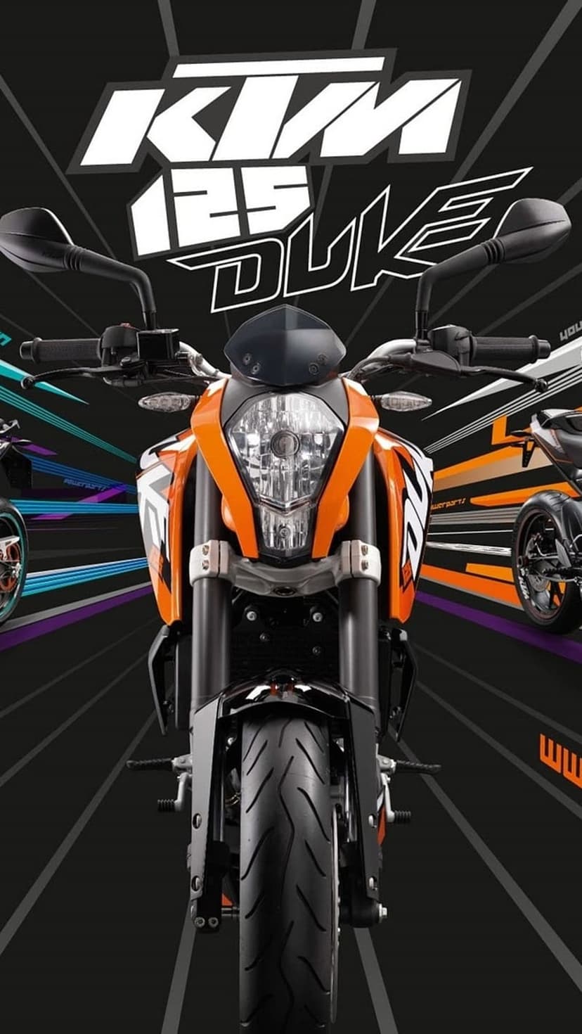 KTM 125 Duke motorcycle with an orange trellis frame and sharp bodywork parked on a city street at dusk.