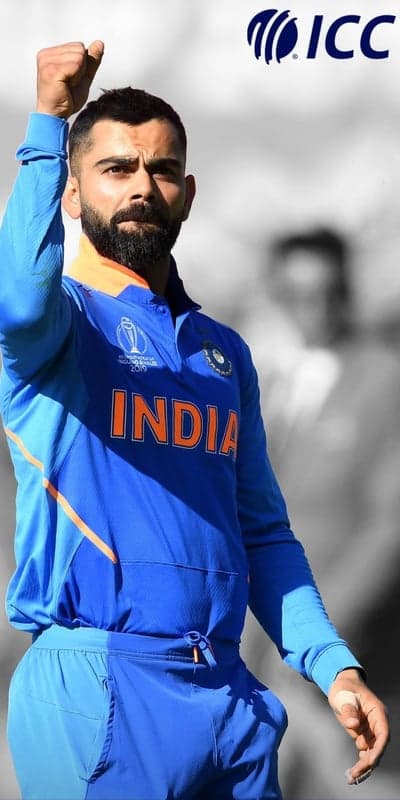 Virat Kohli in India's blue cricket jersey with fist raised