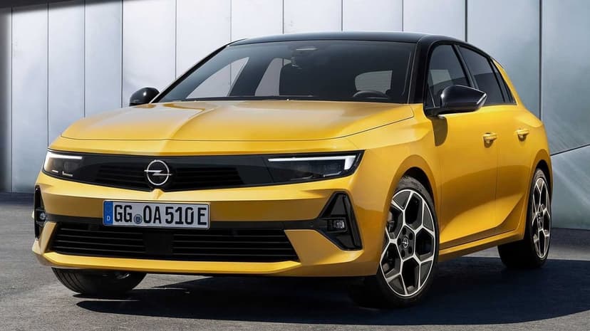 Vibrant yellow Opel Astra hatchback with a black roof parked against a minimalist gray architectural background.