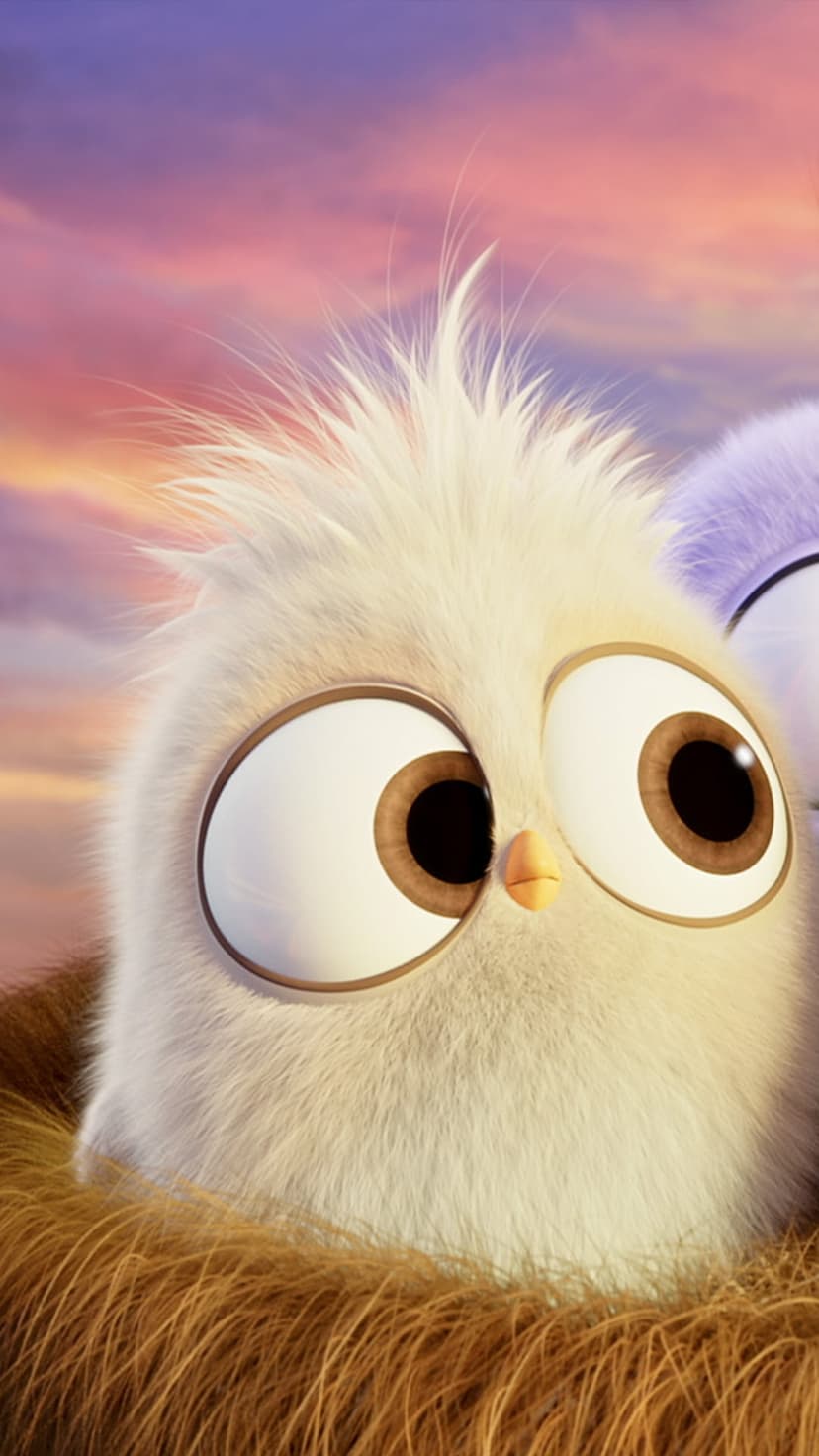 Fluffy baby bird with large eyes sits in a textured nest under a pink and purple sunset sky with soft lighting.