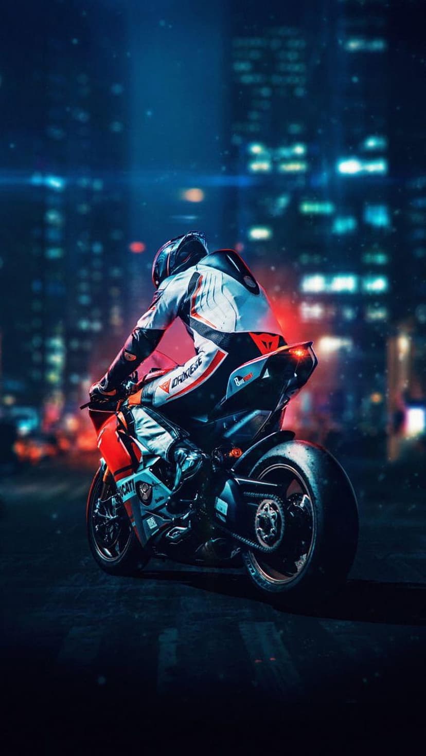 Ducati motorcycle rider in a black racing suit leans into a turn amidst blurred neon city lights at night.