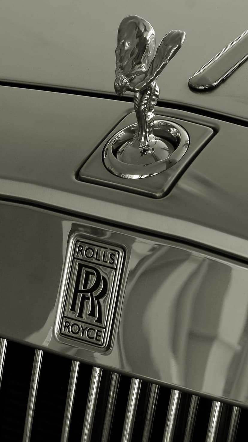 Spirit of Ecstasy hood ornament and Rolls-Royce emblem positioned above a vertical grille in black and white.