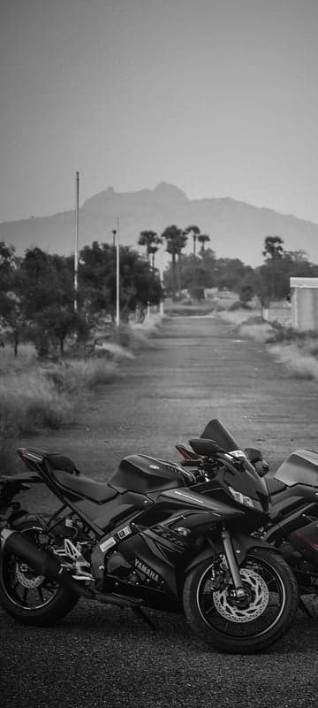 Two Black Yamaha R15 Bikes on a Rural Road