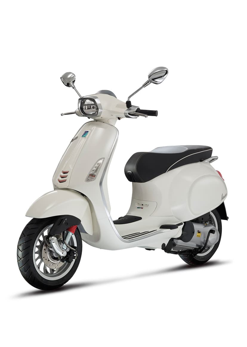 White Vespa Sprint scooter with a black leather seat and chrome mirrors standing on a plain white background.
