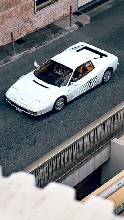 White Ferrari Testarossa driving on asphalt street