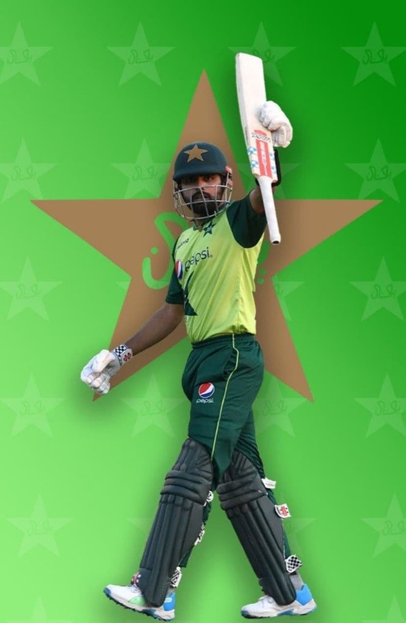 Pakistani cricketer in green uniform raises his bat while walking forward against a lime star and crescent backdrop.