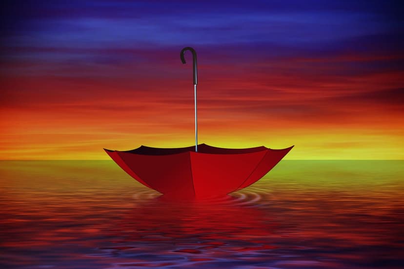 Red umbrella floats on calm water under a gradient sunset sky of orange, yellow, and deep blue light.