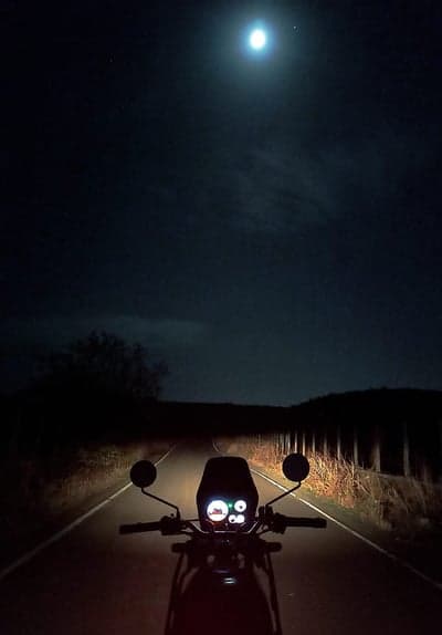 Riding a motorcycle under the full moon at night
