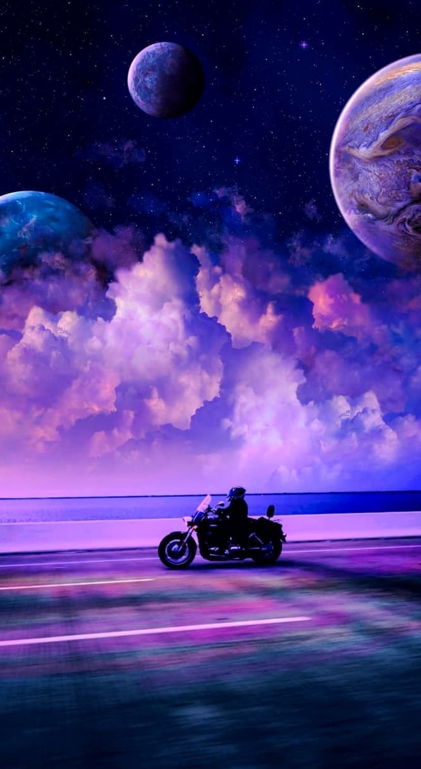 Lone motorcyclist travels on an empty road under a purple sky filled with planets and swirling nebula clouds.