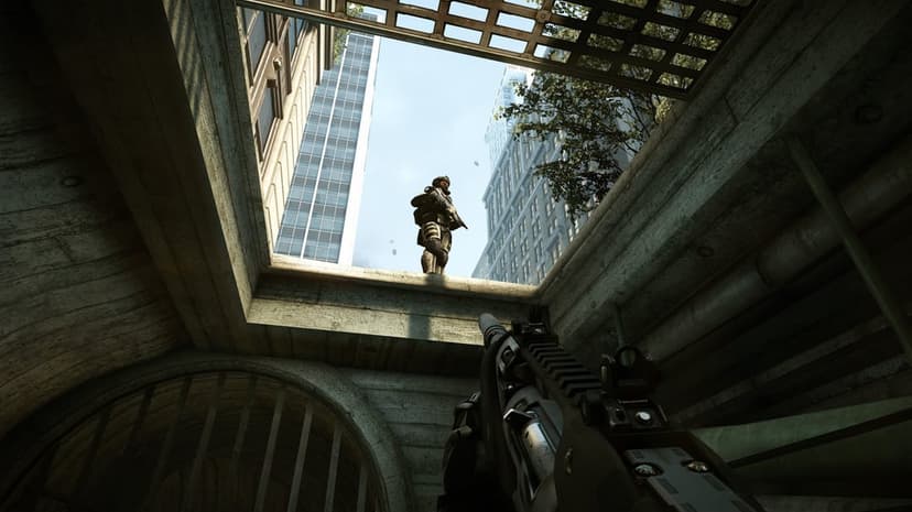 First-person view of a rifle pointed at a soldier standing above a concrete tunnel under city skyscrapers.