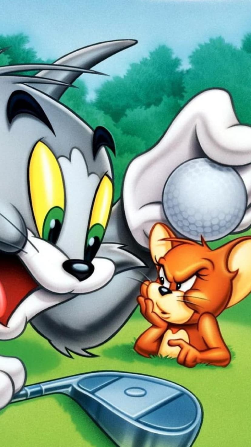 Tom the cat holds a golf ball near Jerry the mouse while a whistle-handled golf club rests on the bright green grass.