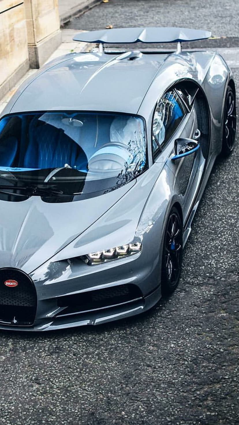 Bugatti Chiron Super Sport 300+ in grey with a blue interior parked on a textured asphalt city street.