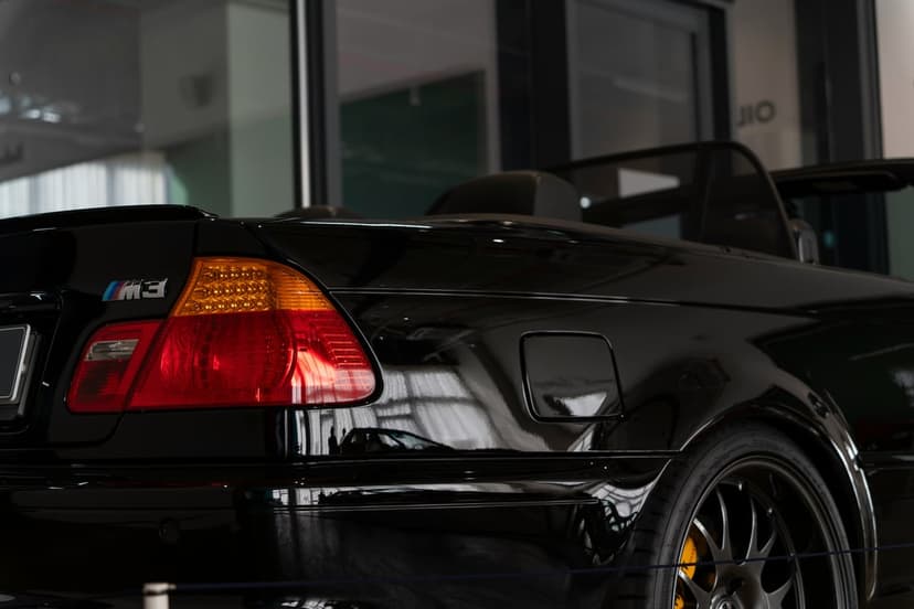 Black BMW M3 rear quarter panel featuring an M3 badge, LED taillight, fuel door, and yellow brake calipers.