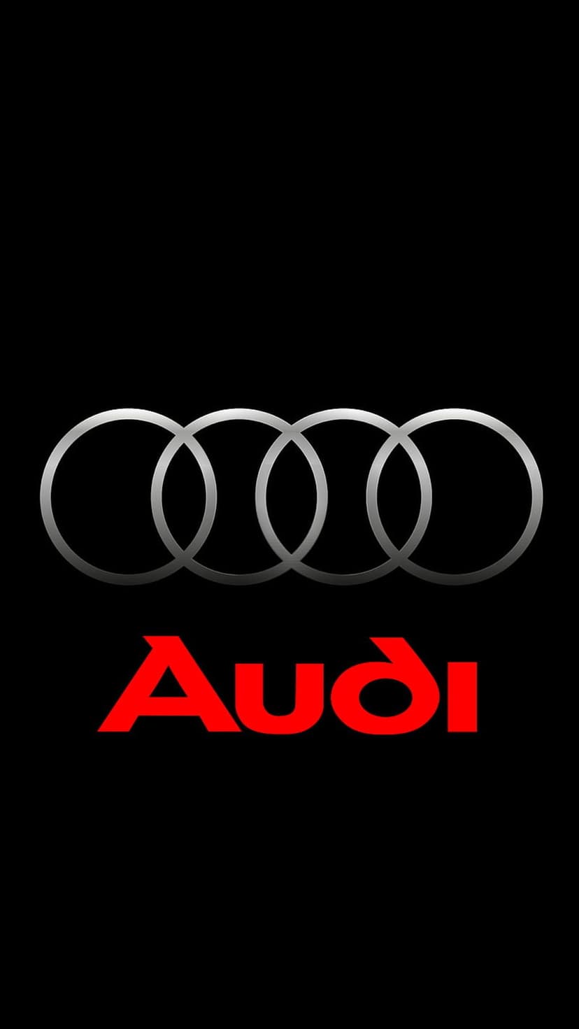 Audi logo featuring four silver interlocking rings above red typography on a seamless black background.