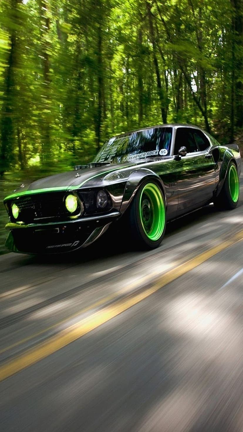 Black Ford Mustang with neon green wheels speeding on a forest road with motion blur in a vertical layout.