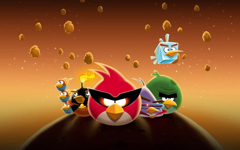 Angry Birds Space characters stand on a rocky asteroid surface under a warm orange and dark starry sky.