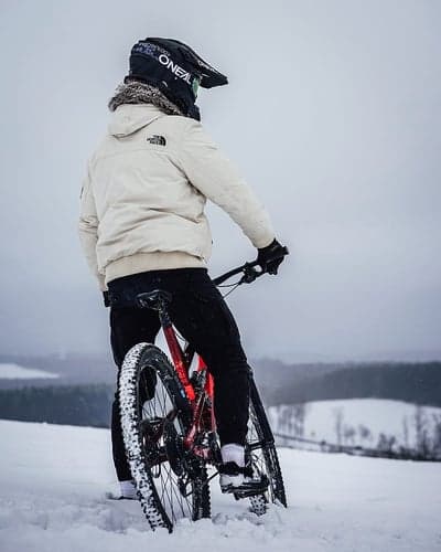Mountain biker in snow wearing helmet and jacket