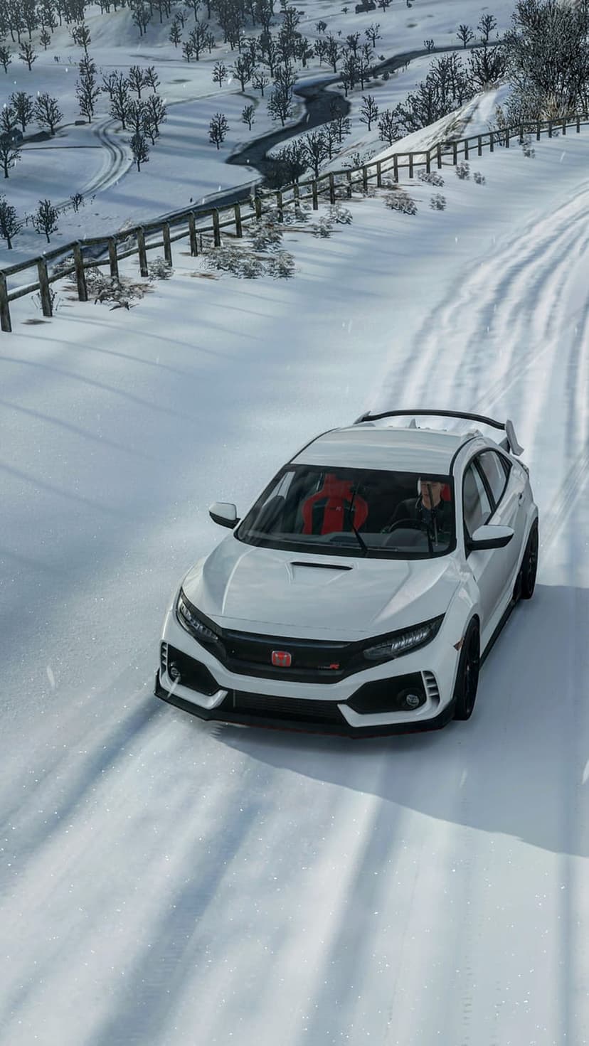 White Honda Civic Type R drifts on a snowy mountain road with bare trees and a rear wing visible in winter light.