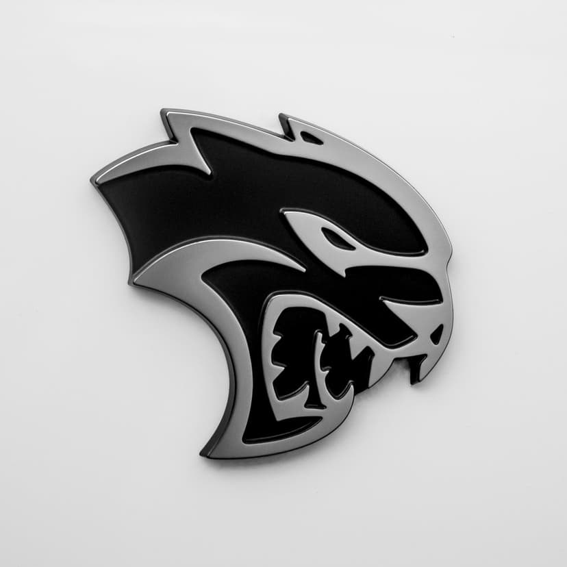 Snarling Hellcat emblem with polished silver edges and matte black inlay on a neutral white background.