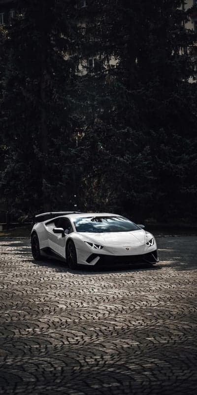 White Lamborghini Huracan Evo parked on cobblestone street