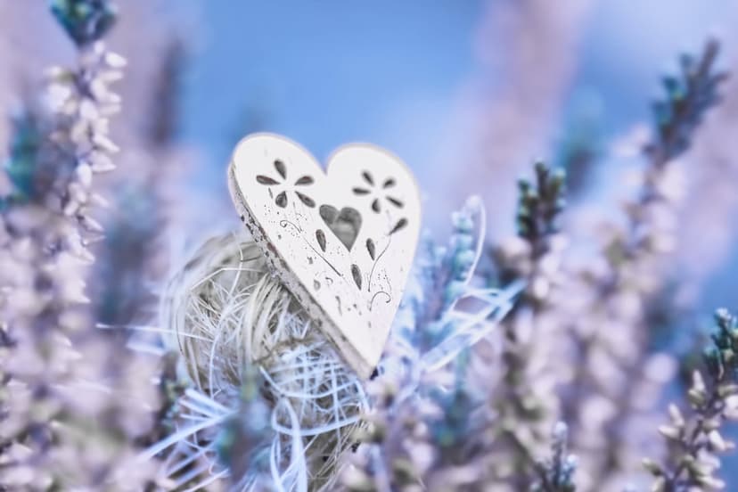 Intricately carved white floral heart resting on a twine ball within a soft-focus purple lavender field.