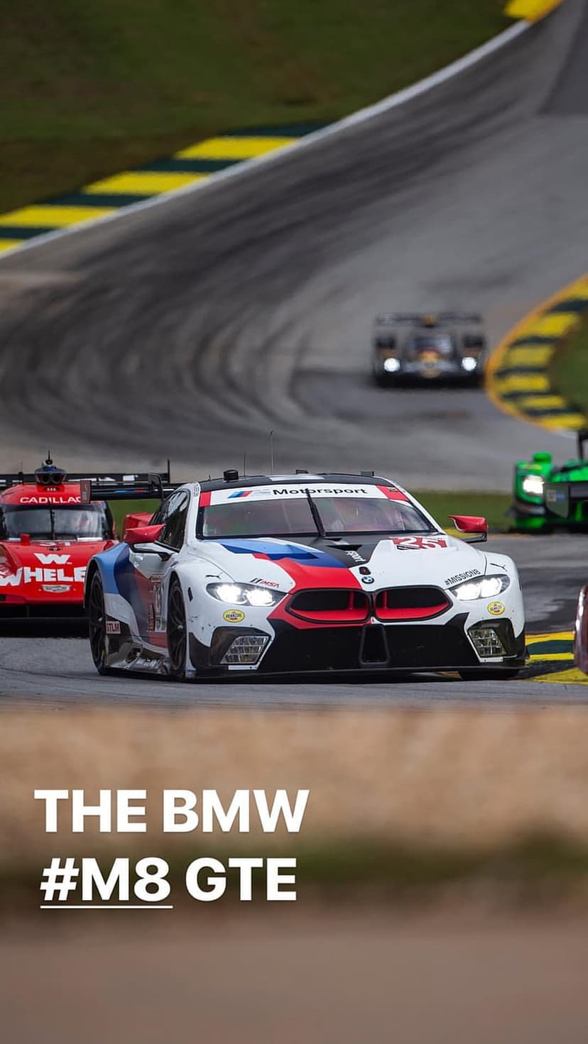 BMW M8 GTE race car with motorsport livery speeds on a track with motion-blurred racing cars in the background.