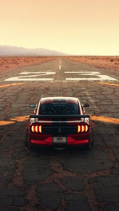 Red Mustang on Desert Runway at Sunset