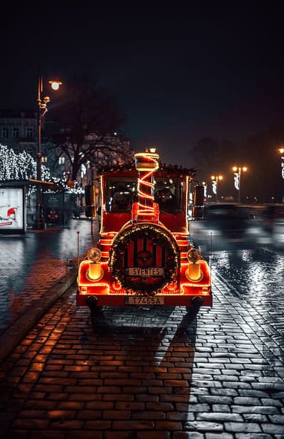 Festive red train decorated with Christmas lights at night