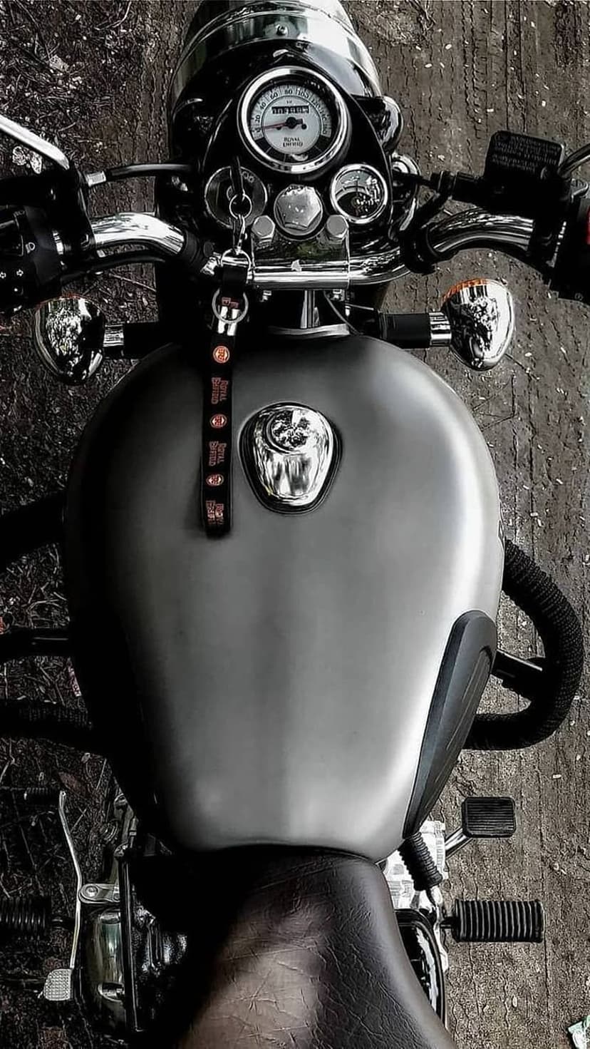 Royal Enfield motorcycle from a top view with a matte gray fuel tank, chrome handlebars, and round analog gauges.