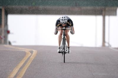 Cyclist Races Down Road in Light Rain