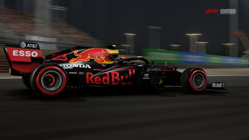 Side view of a black Red Bull F1 car with glowing red tires racing at night with motion blur on a dark track.