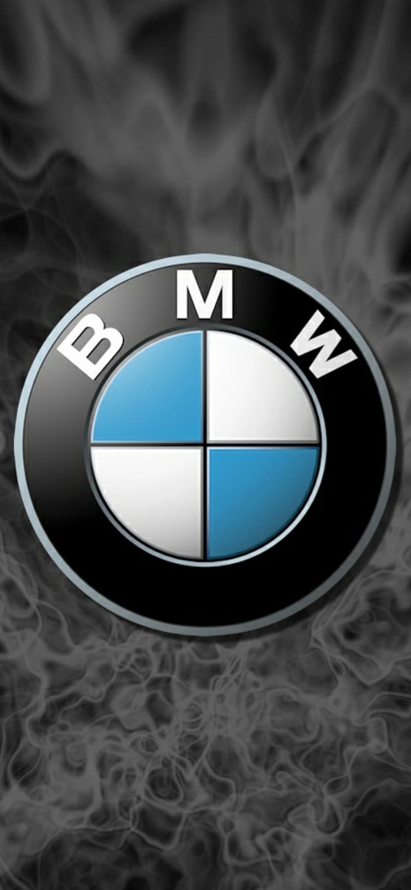 BMW logo with blue and white quadrants centered in a dark grey background filled with thick swirling smoke.