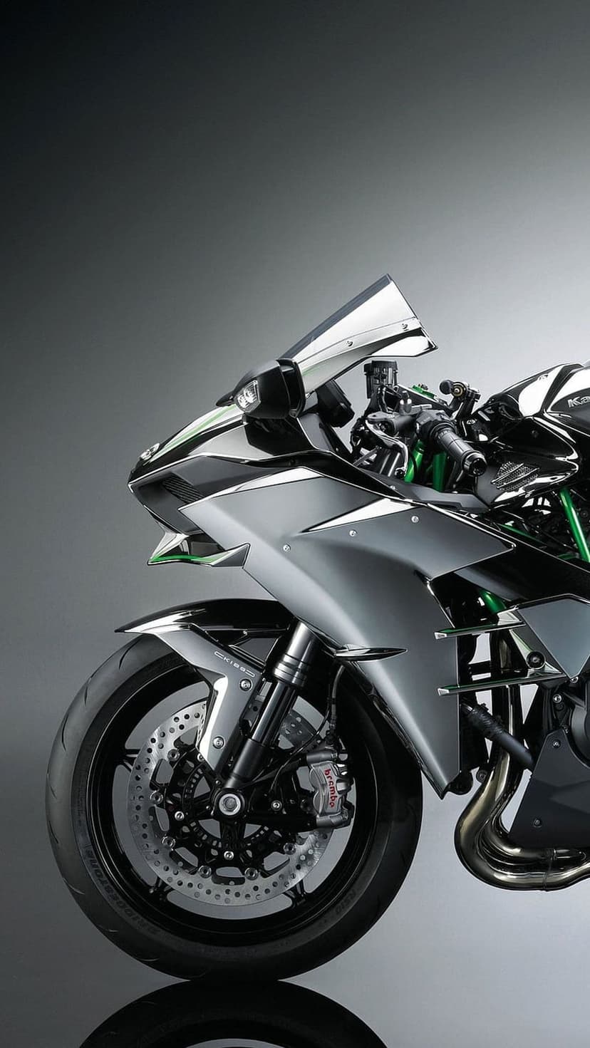 Kawasaki motorcycle with green frame details, polished silver fairings, and a prominent front disc brake system.