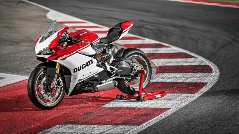 Red and white Ducati 1299 Panigale S Anniversario parked on a racetrack kerb using a rear paddock stand.