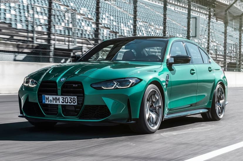 Green BMW M3 sedan driving on a racetrack with motion-blurred wheels and stadium seating background.
